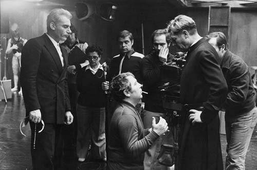 Elio Petri, inginocchiato, sul set di Todo Modo tra Gian Maria Volonté e Marcello Mastroianni